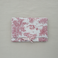 Pochette à livre matelassée en toile de Jouy rose avec noeud pour fermeture